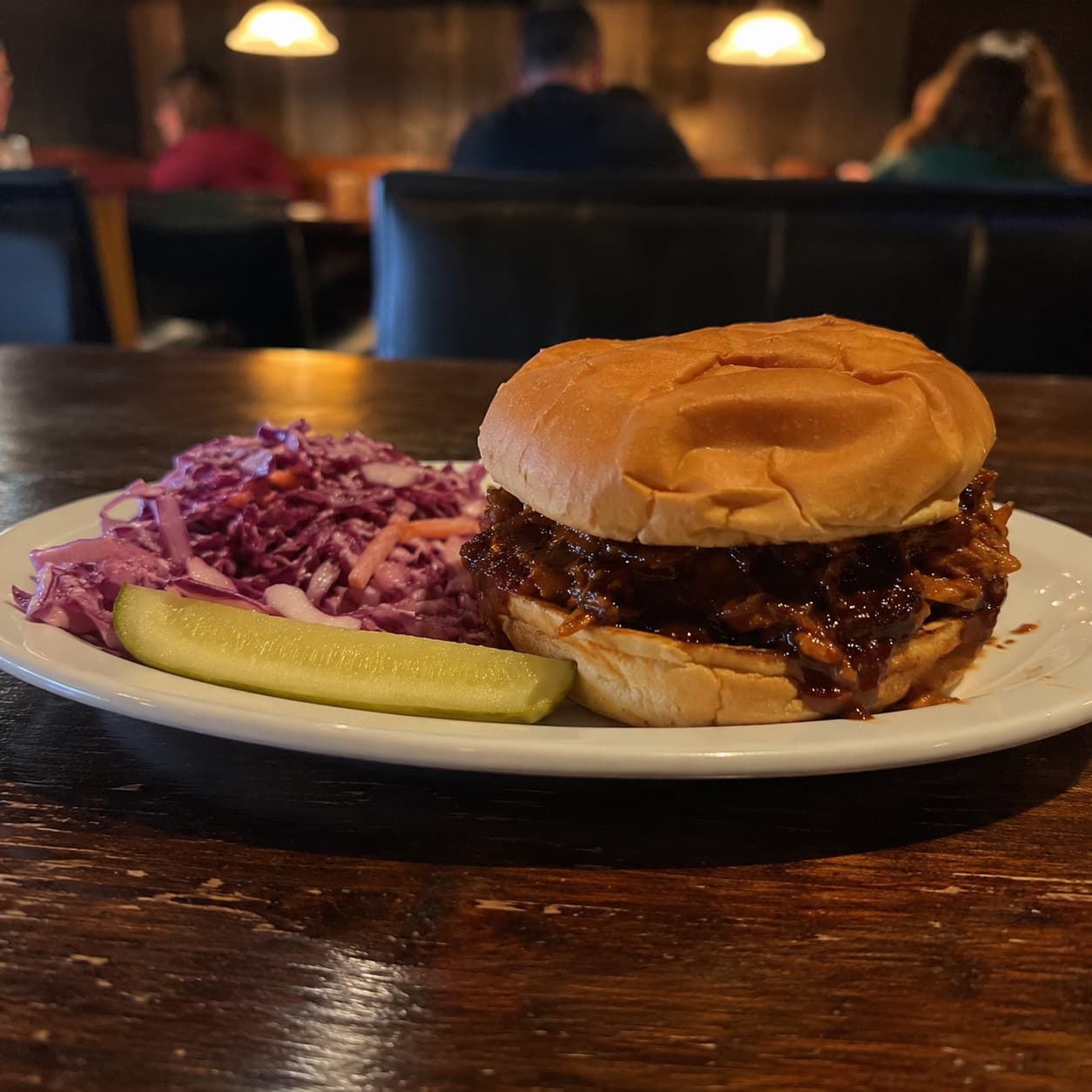 A BBQ jackfruit sandwich photographed on a phone in flat indoor light
